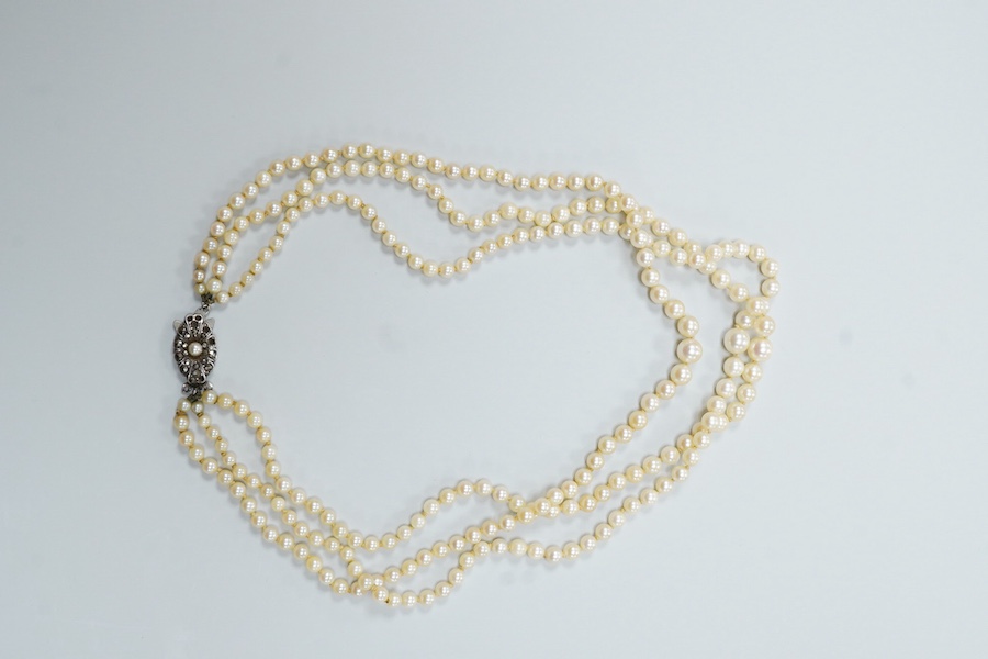 A triple strand graduated cultured pearl necklace, with marcasite set sterling clasp(a.f.), approximately 38cm.